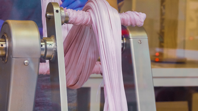 Stretching purple taffy on taffy machine
