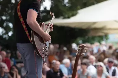 A guitarist playing at an outdoor concert.