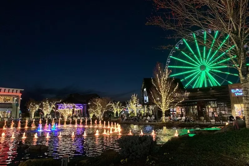 The fountain at The Island in Pigeon Forge at night with lit-up trees and wheel