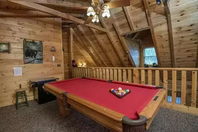 pool table and arcade game in game room loft at The Getaway cabin