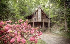 A wonderful log cabin in Pigeon Forge TN with flowers growing out front.
