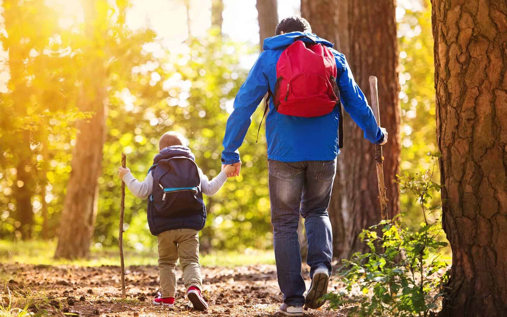 A father and son hiking in the forest.