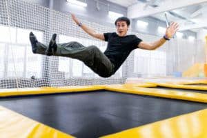 A young man jumping on a trampoline.