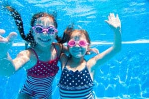 two girls underwater in swimming pool