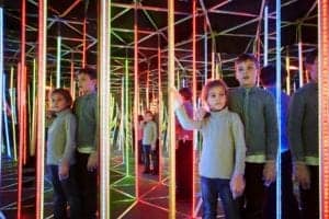 A boy and a girl exploring a mirror maze