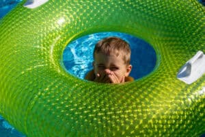 boy covering his face and smiling in lazy river
