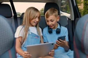 kids using electronics on car ride